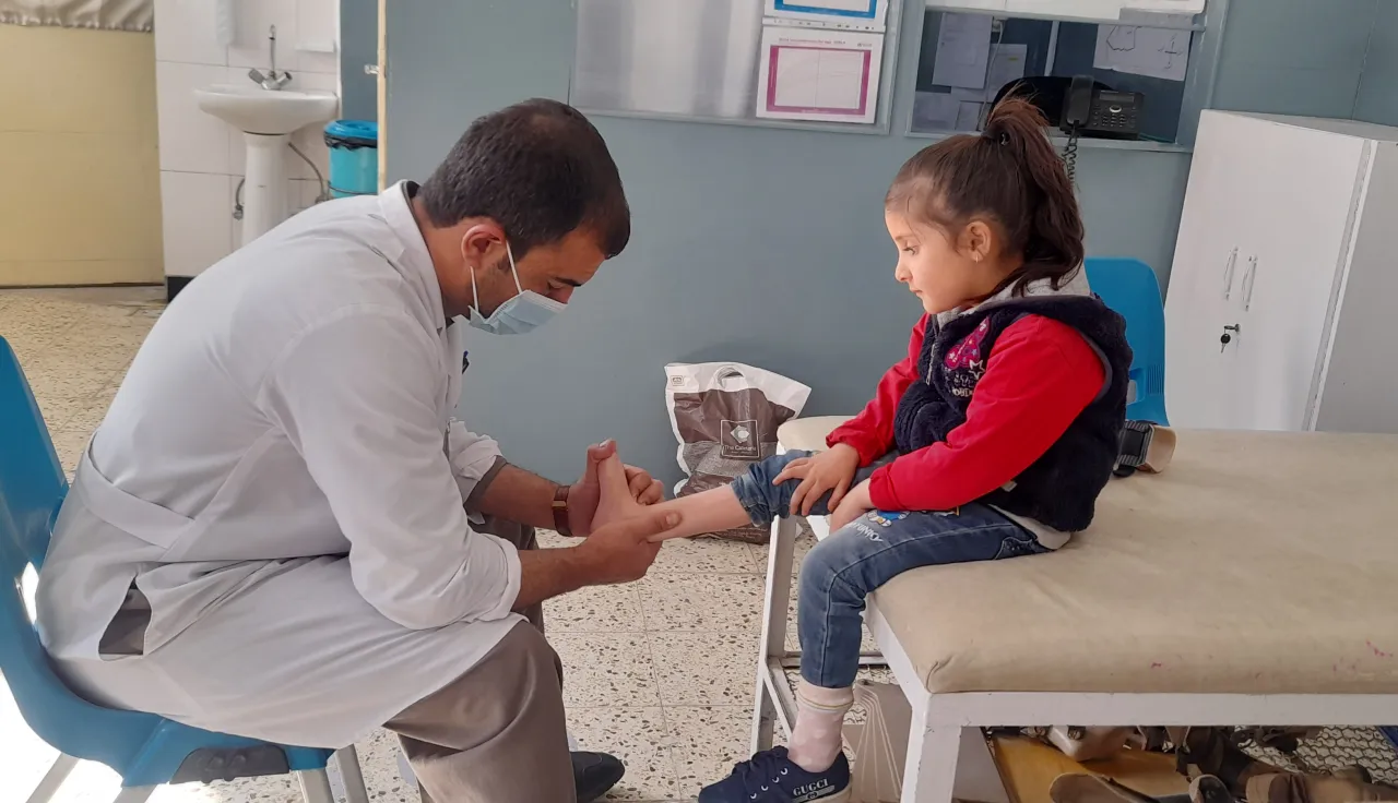 A doctor examining a child at an ICRC-supported rehabilitation centre in Afghanistan